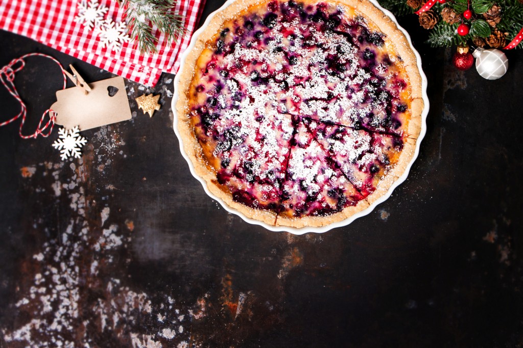 Homemade christmas pie with wild berries and sour cream, christmas decoration, top view with copy space, selective focus